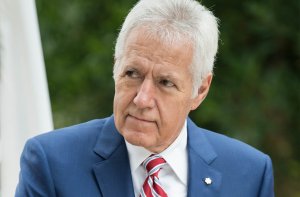 Alex Trebek with a serious face and a blue suit