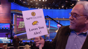 Kirk Hessler, who attended the "Jeopardy!" taping with the Taft College crew, holds up a sign for Alex Trebek reading "Taft College Loves You Alex!"